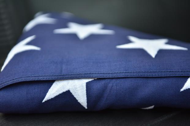 The U.S. flag sits atop a case containing the possible remains of unidentified U.S. service members.