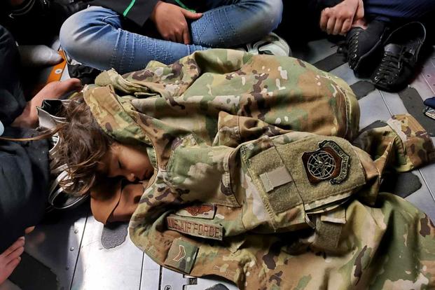 An Afghan child sleeps on the cargo floor of a U.S. Air Force C-17