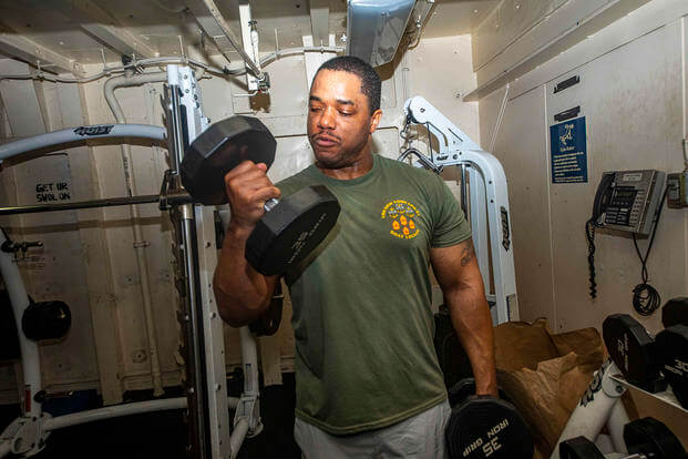 A sailor lifts weights aboard the USS New York.