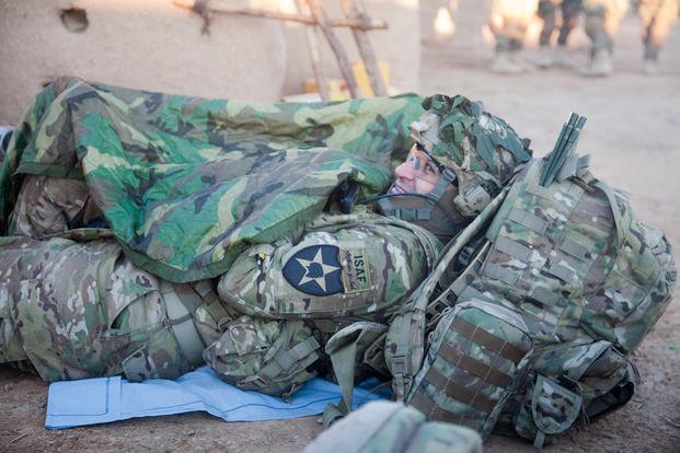 A U.S. Army captain covers himself with a poncho liner during a break in Afghanistan.