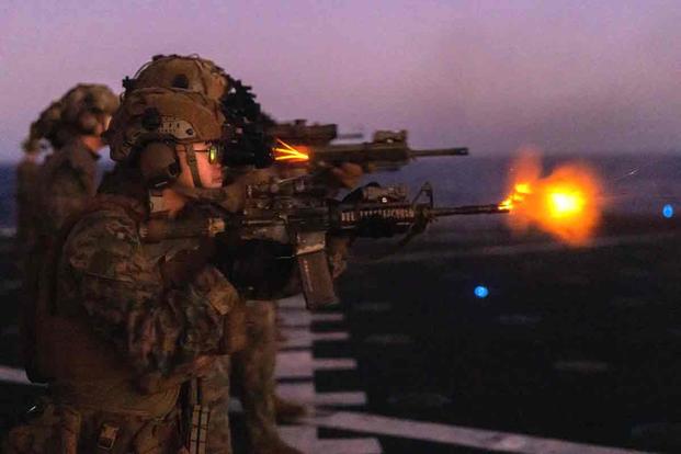U.S. Navy sailor fires an M4 Carbine during a night range