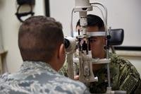 Capt. Joeseph Sarcone, Doctor of Optometry, demonstrates how to use the various equipment used in optometry with a technician at Naval Air Station II (NAS) Sigonella on May 13, 2019. Sarcone worked with many patients performing eye exams. (Katelyn Sprott/Air Force)