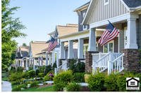 row of white houses with American flags