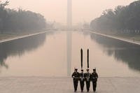 Marine Corps honor color guard rehearse in Washington amid layer of smoke.