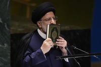 Iran’s President Ebrahim Raisi kisses a Quran