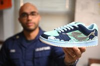 Petty Officer Second Class Kenneth Jones presents his own custom-created sneaker from an online competition in Norfolk, Virginia.