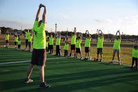 Lt. Col. James Coughlin conducts warmup exercises during the Keesler Dragons Family Running Club practice at the Triangle Track, Keesler Air Force Base, Miss. (Kemberly Groue/U.S. Air Force photo)