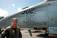 Lt. Cdr. Michael Tremel stands next to his F/A 18-E Super Hornet on board the USS George W. Bush last July. The tomahawk symbols represent strike missions and the &quot;kill&quot; symbol for his shootdown is upper right. (Photo courtesy of Save The Royal Navy)